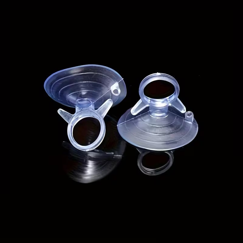 Two clear aquarium suction cups with ring holders on a black background