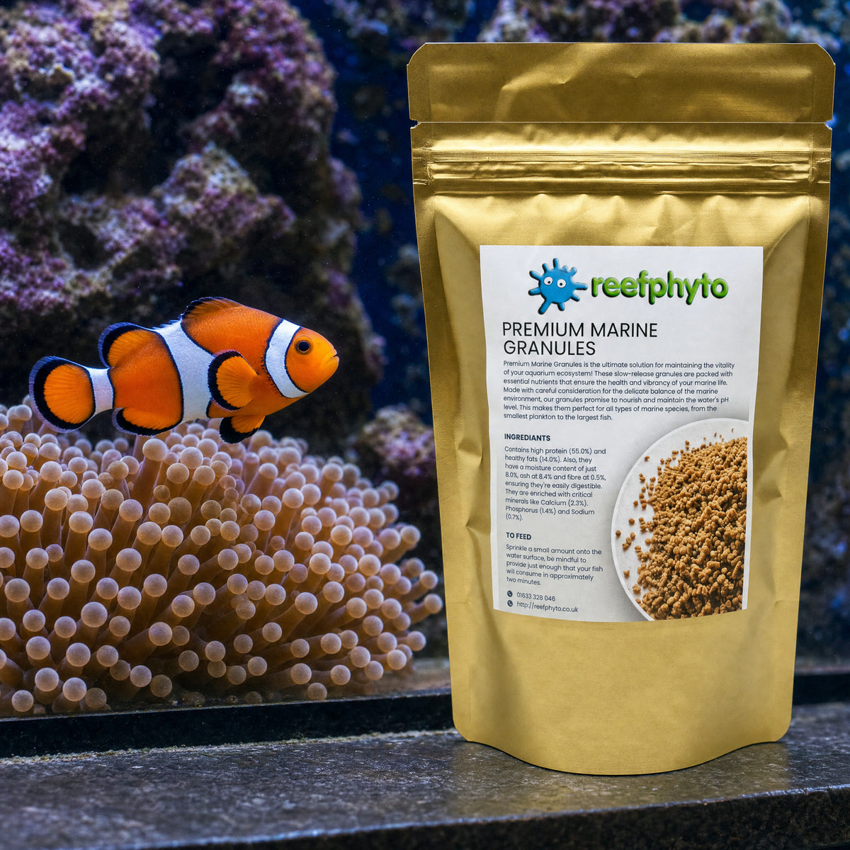 Reefphyto Premium Marine Granules pouch beside a clownfish and bubble-tip anemone