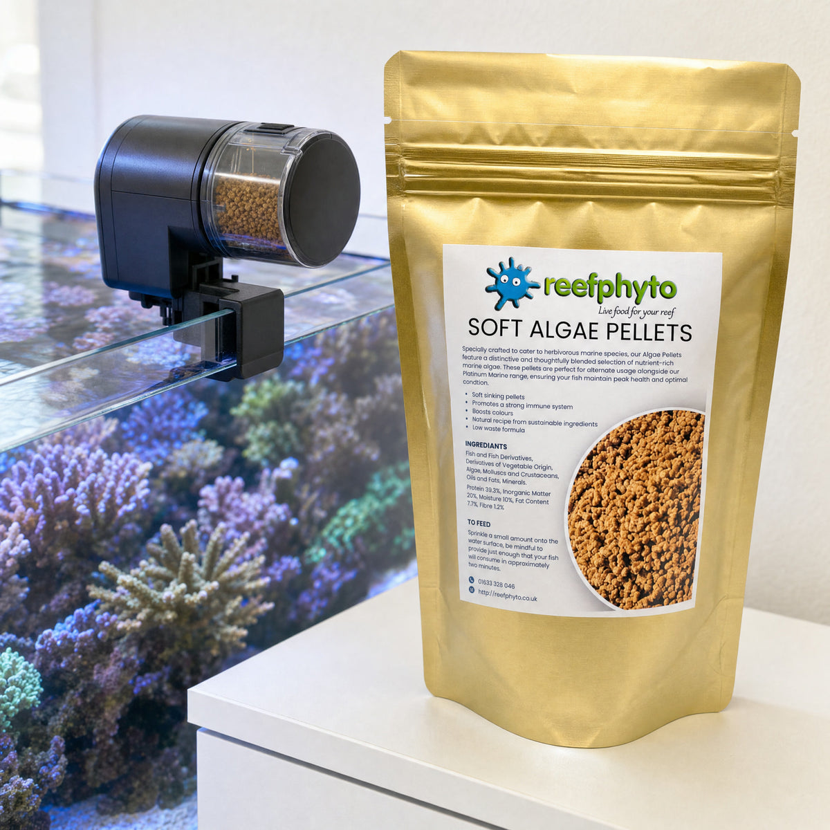 Reefphyto Soft Algae Pellets pouch beside an automatic feeder loaded with pellets on a reef tank